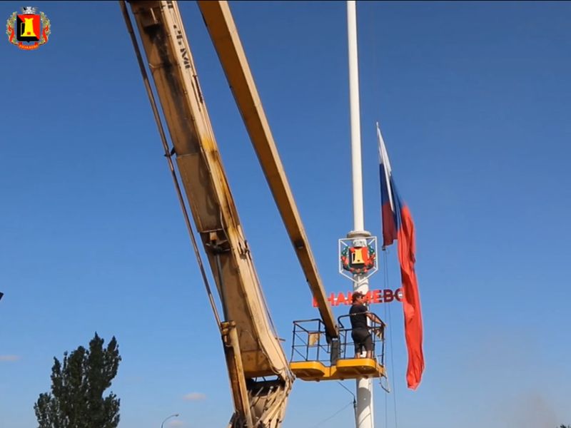 Церемония поднятия флага России над стелой при въезде в Енакиево.